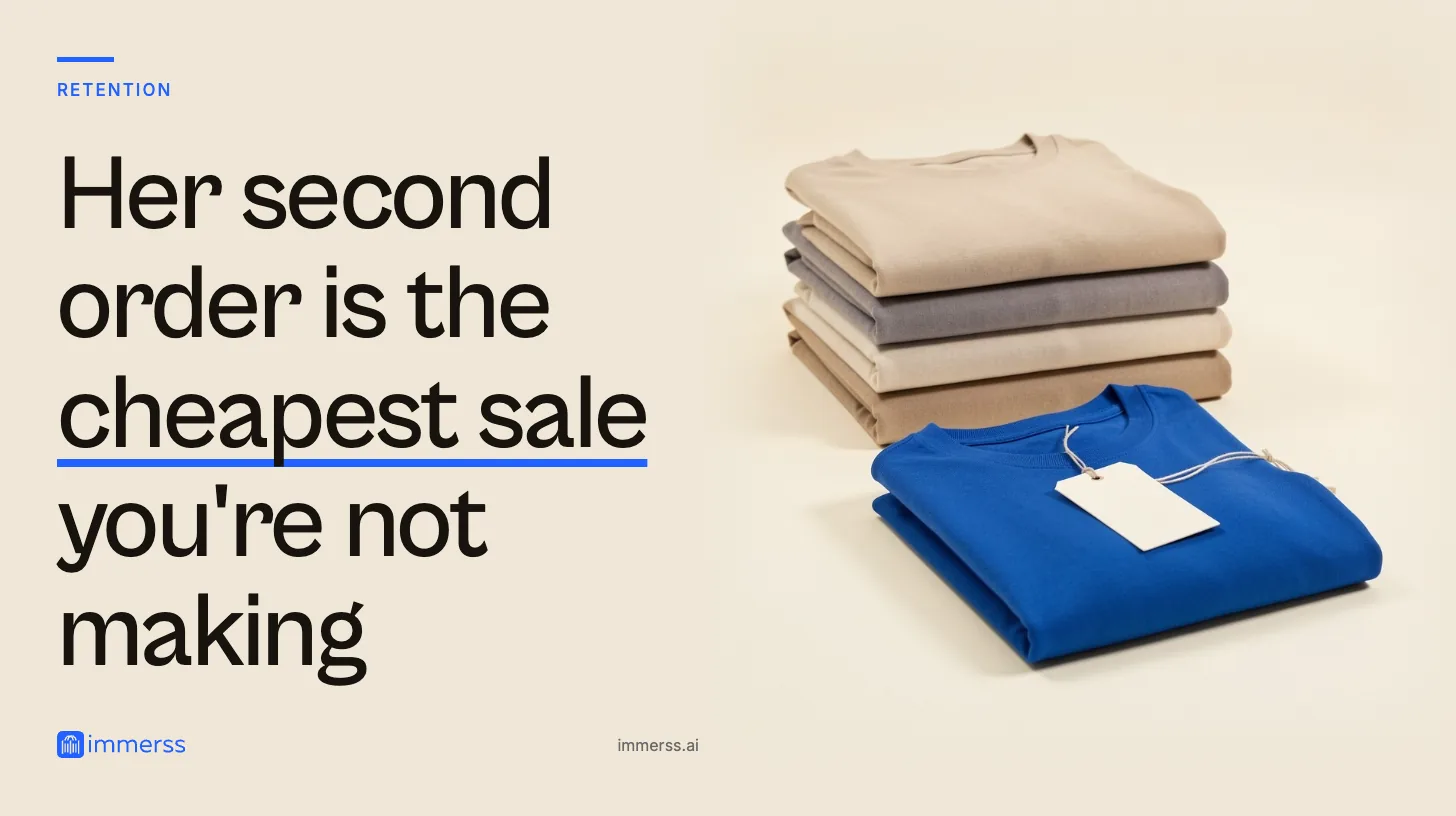 Her second order is the cheapest sale you're not making. A single folded garment with a blank tag on a string, set apart in front of a stack of four folded garments